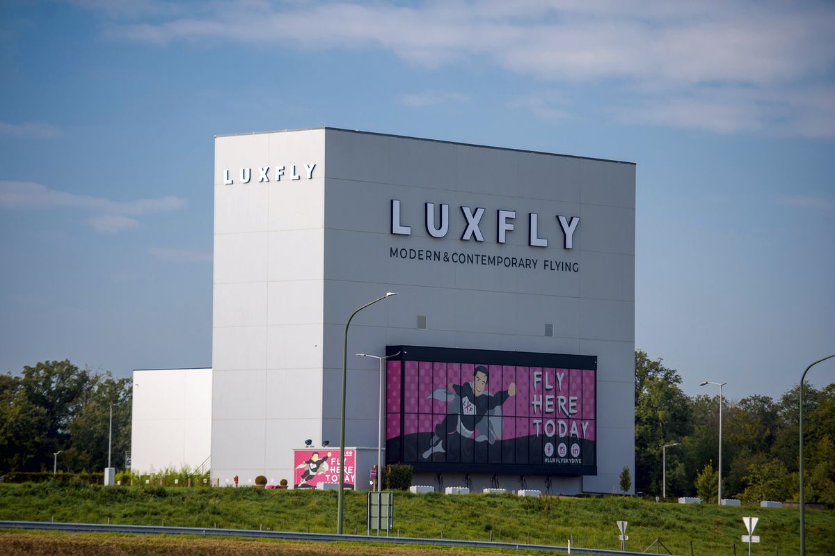 Le bâtiment LUXFLY vu depuis la route, avec l'enseigne LUXFLY et l'écran géant